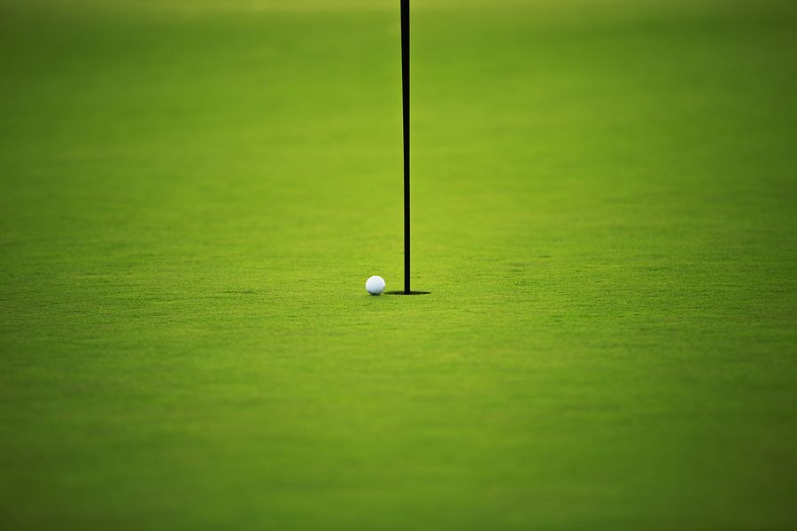 Ball near golf hole on the green