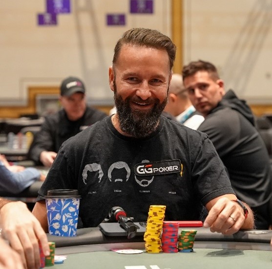 Daniel Negreanu smiling while at a poker table. 
