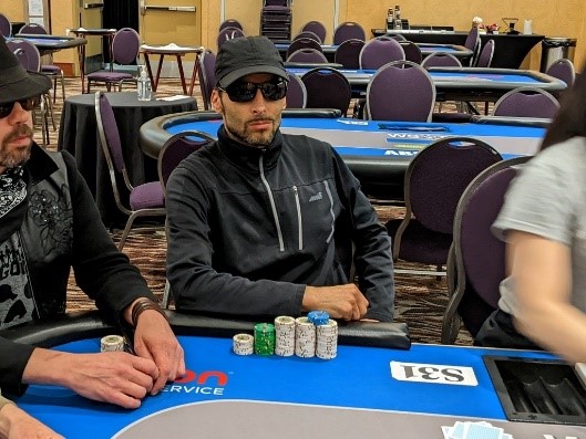 Paul Sokoloff chilling at a poker table wearing sunglasses.