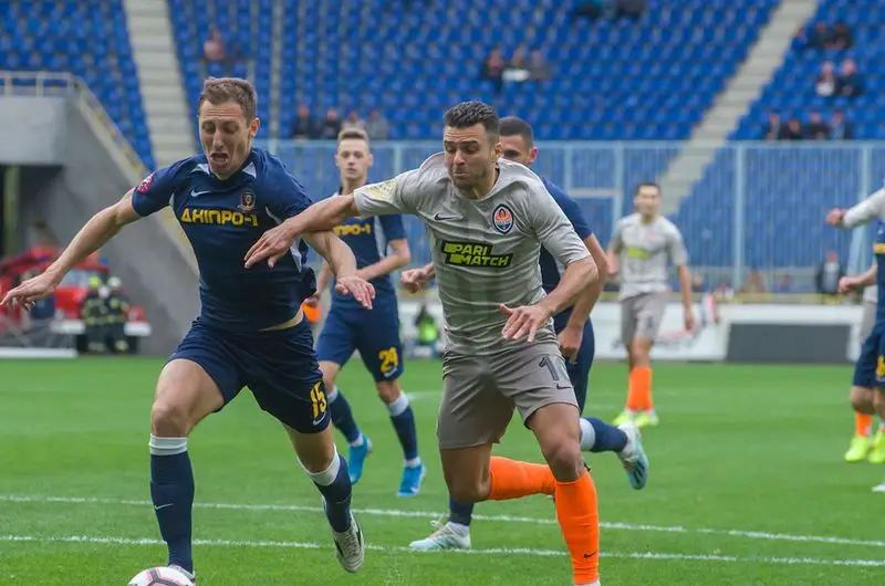 Two players running after the ball at soccer.