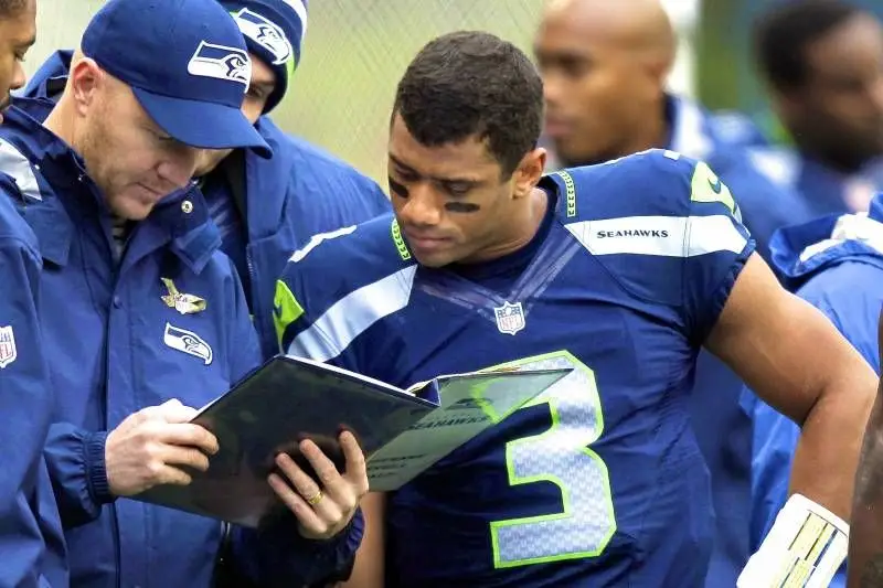 American football player reading tactics from coach