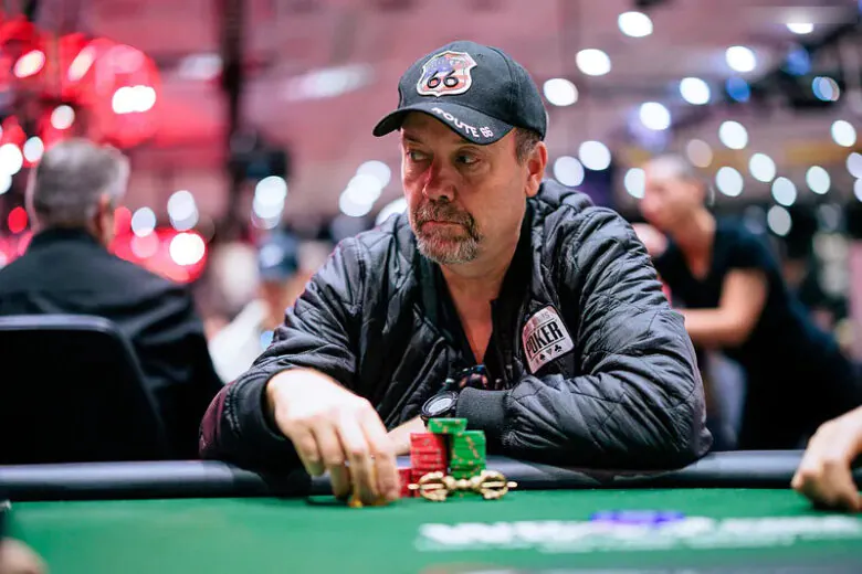 A focused Andy Black, known as "The Monk," sits at a poker table during a high-stakes tournament.